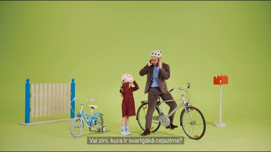 Bērns mācās droši pārvietoties ar elektroskrejriteni pilsētvidē